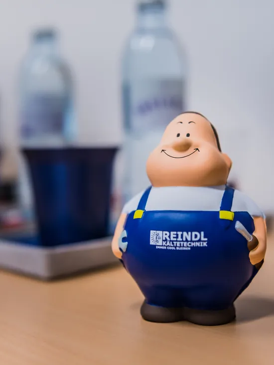 Lächelnde Figur in blauer Uniform auf Tisch mit unscharfem Hintergrund