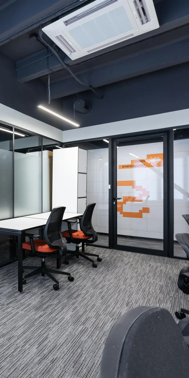 Modernes Bürointerieur mit Schreibtischen, Stühlen und Glaswänden